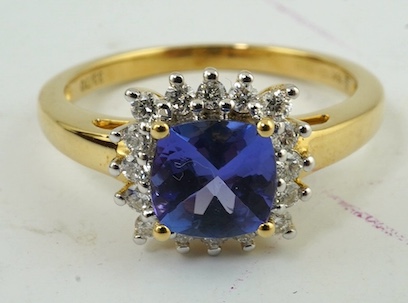 A modern 18ct gold, tanzanite and diamond cluster set ring, with AnchorCert report estimating the cushion cut tanzanite to weigh 0.90ct, size O, gross weight 3.5 grams. Condition - good